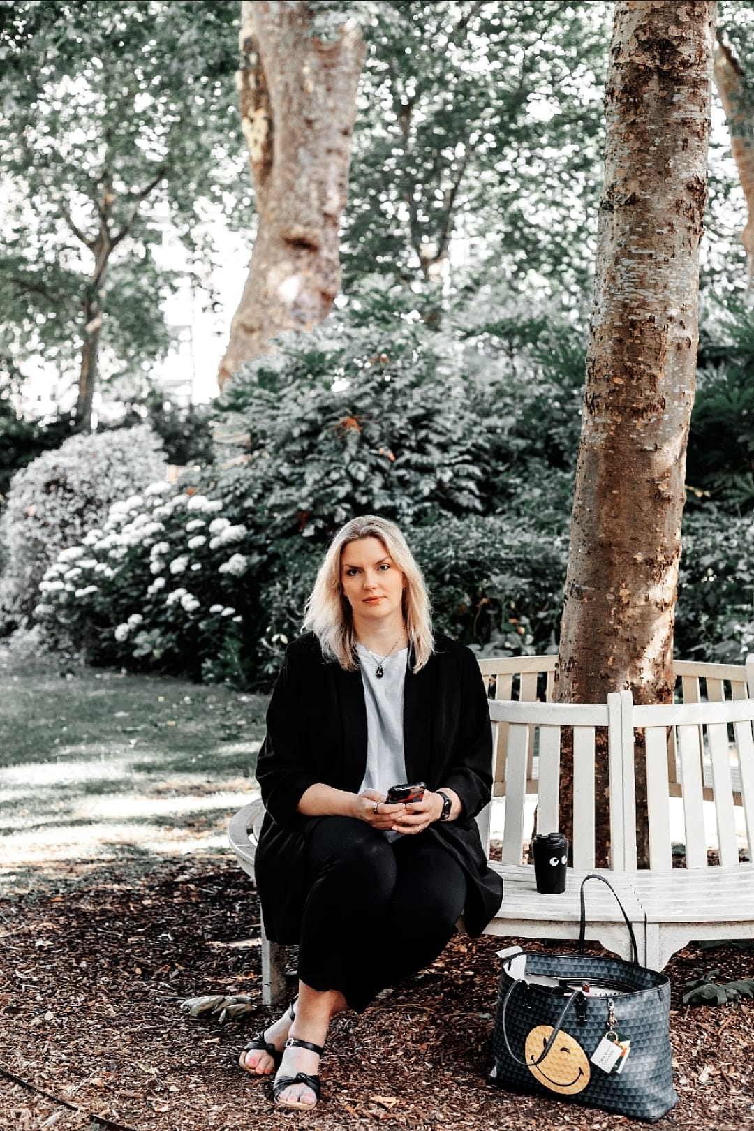 Business consultant seated on a white bench in a park, representing professional keynote speaking services