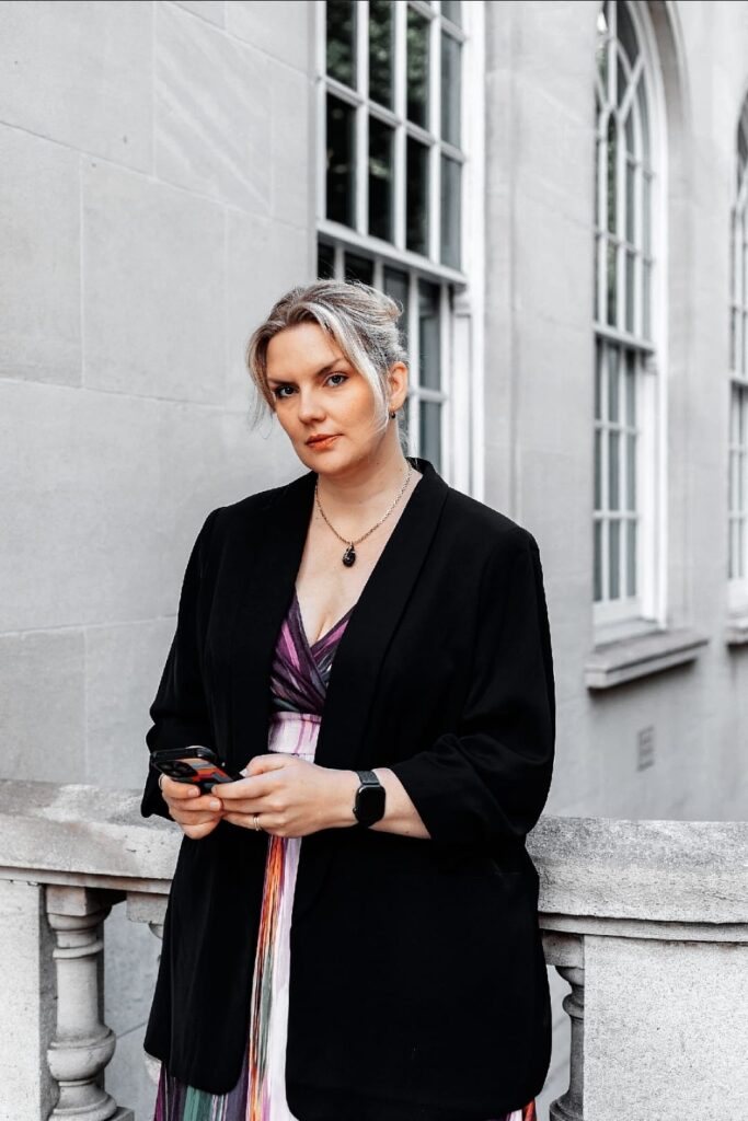 Business consultant holding a phone outside a historic building, offering strategic consulting and Fractional COO services.