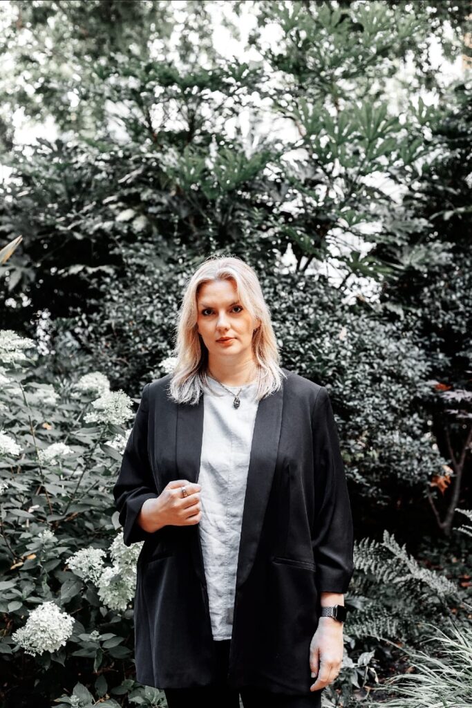 Business consultant standing in a lush green garden, ready to offer VIP intensive strategy sessions.